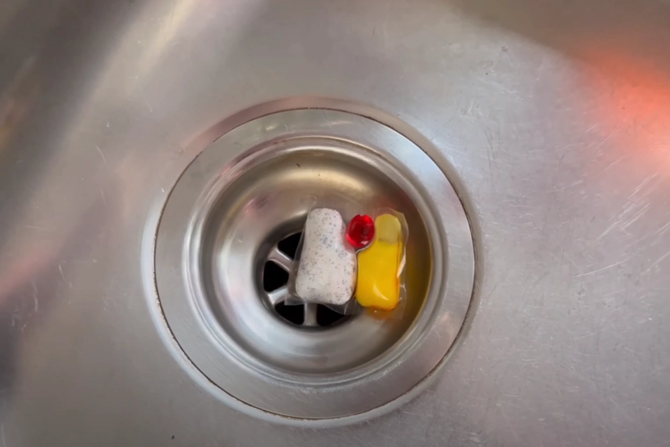 Han lægger en opvasketabs i vasken og hælder 1,5 liter kogende vand på: Med et snuptag er velkendt køkkenproblem løst